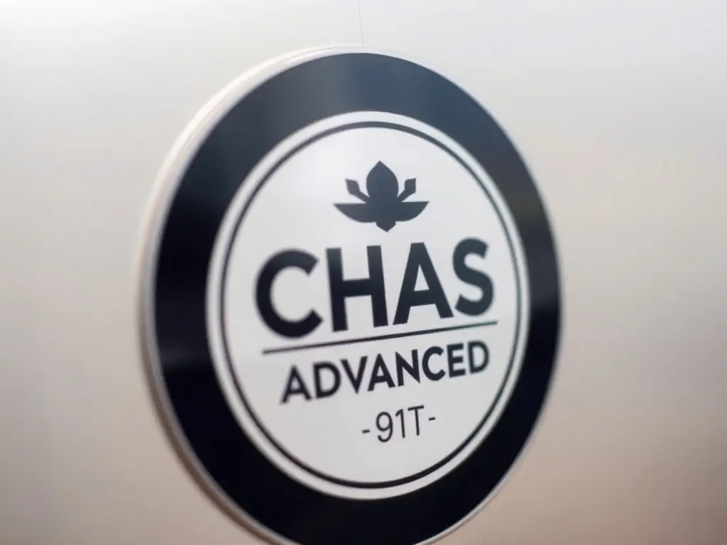 A close-up shot of the CHAS Advanced accreditation logo, symbolizing compliance and high standards in construction and landscaping.
