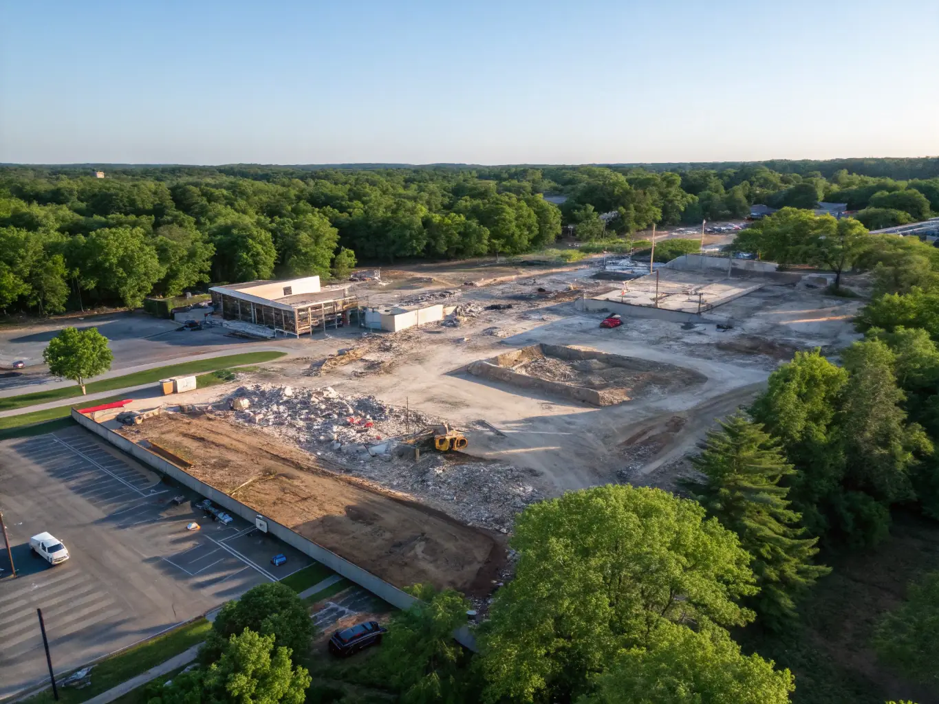 An aerial view of a construction site after Evenii Grounds Contractors has completed site clearance, showing a clean and prepared area ready for building, with machinery neatly parked.